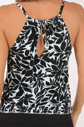 Woman wearing a black and white floral tankini set on a white background