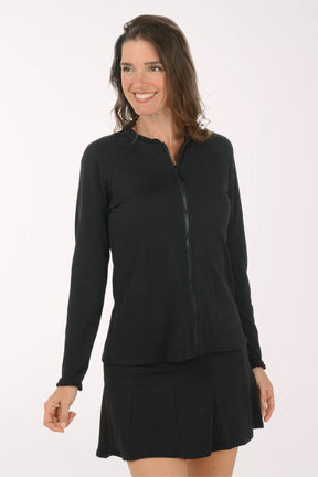 Woman wearing a black long-sleeve top and skirt on a white background.