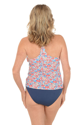 A woman wearing a multi colored floral tankini swim top. Back shot.