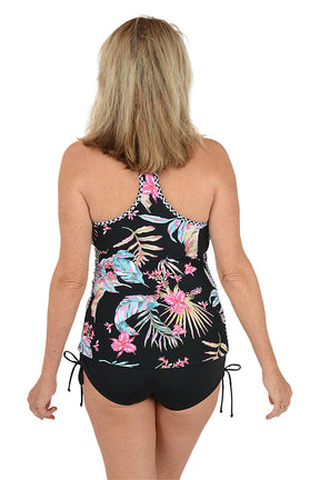 Woman wearing a black swimsuit with colorful floral and feather design on a white background