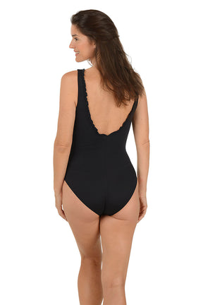 Woman wearing a black one-piece swimsuit on a white background. Back shot.