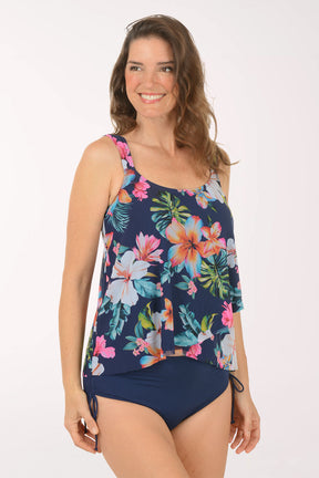 A woman wearing a navy blue multicolored floral tankini top.