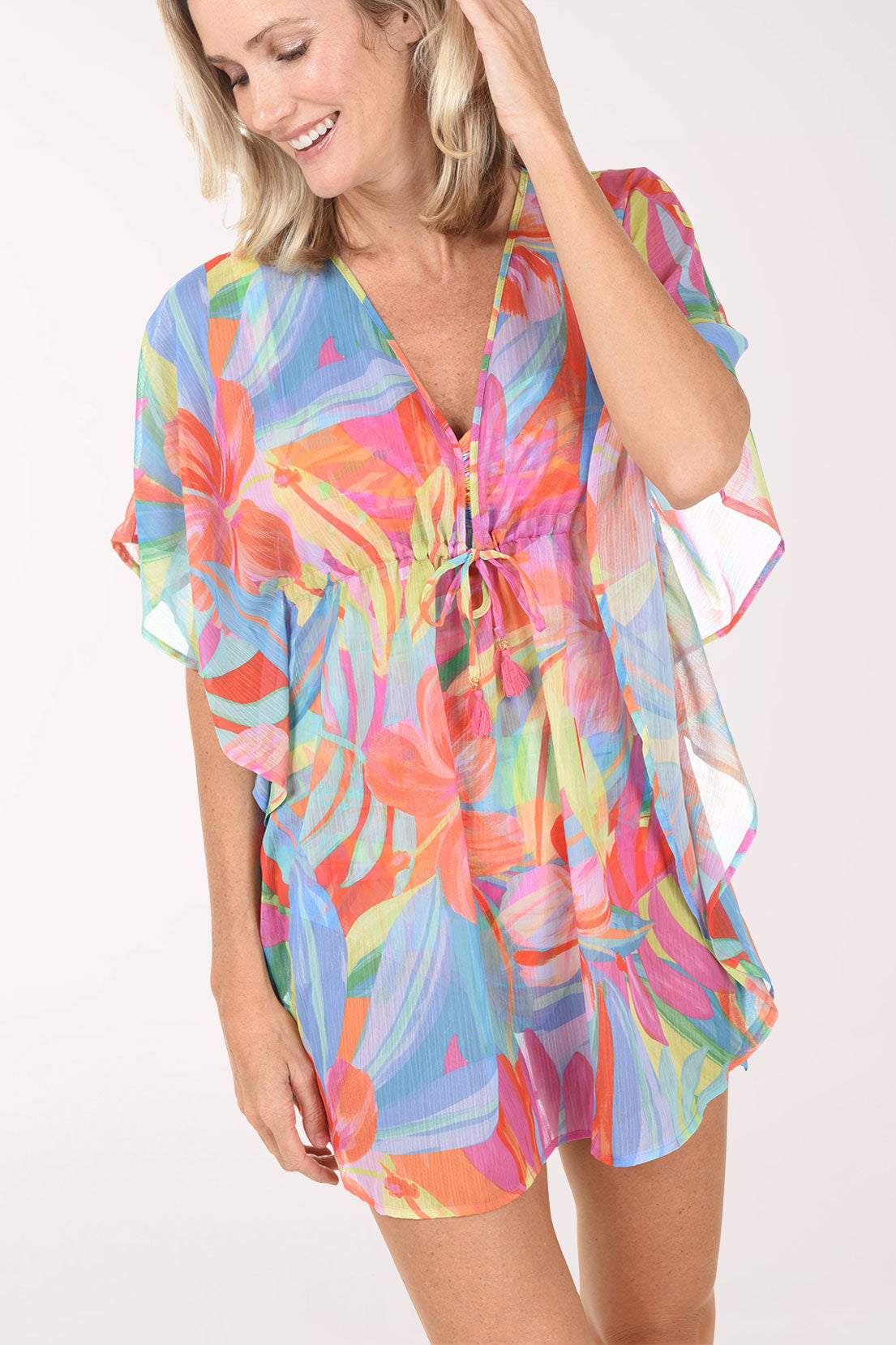 Woman wearing a colorful tie-dye cover-up on a white background