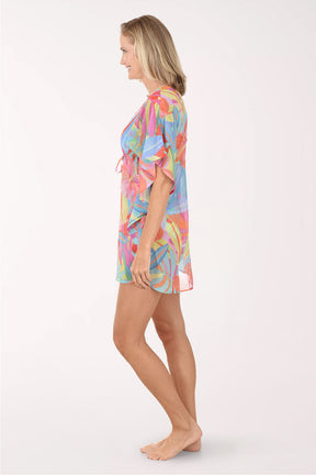 Woman wearing a colorful tie-dye cover-up on a white background