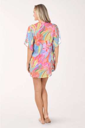 Woman wearing a colorful tie-dye cover-up on a white background