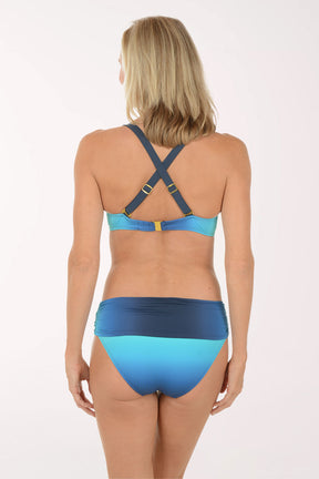 Woman wearing a blue and green bikini on a white background. Back shot.