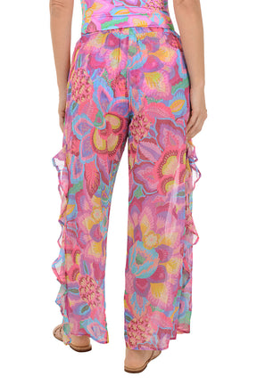 Person wearing a colorful floral wide-leg pants on a white background. Back shot.