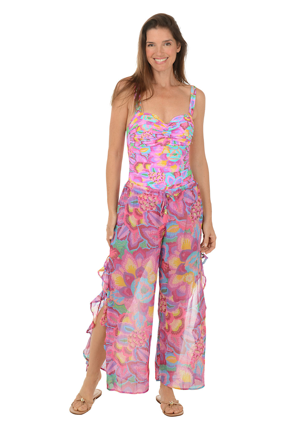 Person wearing a colorful floral wide-leg pants on a white background. Full length shot.