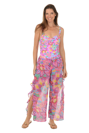 Person wearing a colorful floral wide-leg pants on a white background. Full length shot.