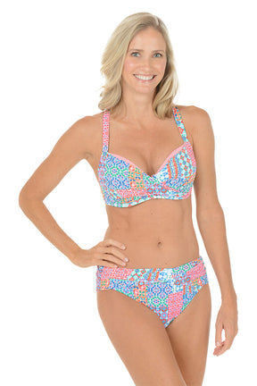 A woman wearing a multi-colored bikini top with a twist front detail.