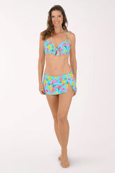 Woman wearing a colorful floral bikini set on a white background