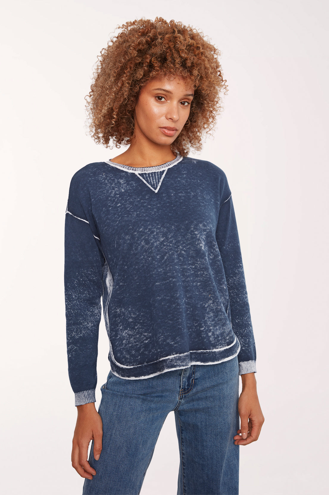 Woman wearing a blue acid wash long sleeve sweater 