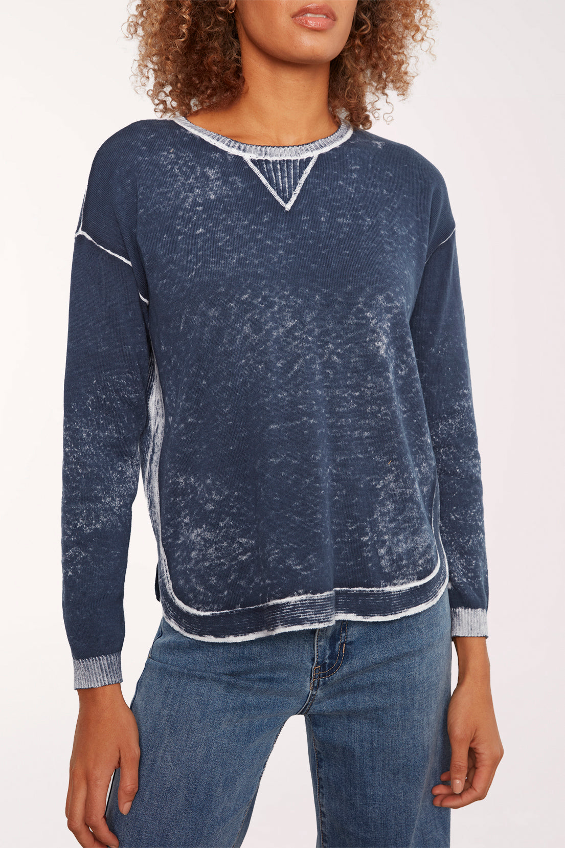 Woman wearing a blue acid wash long sleeve sweater 