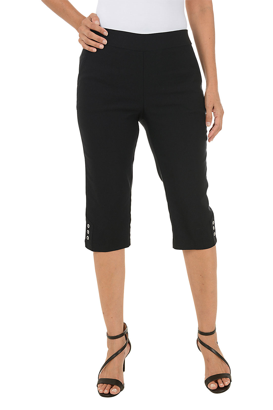 Person wearing black capri pants on a white background.