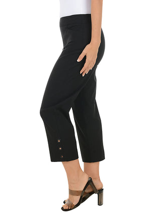 Black crop pants worn by a person on a white background. Side shot.