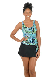 Woman wearing a colorful tank top and black skirt on a white background.