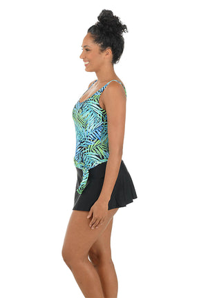 Woman wearing a colorful tank top and black skirt on a white background. Side shot.