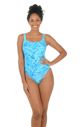 Woman wearing a blue patterned swimsuit on a white background.