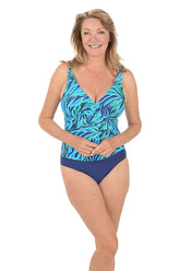 Woman wearing a blue and green patterned one piece with navy bottoms on a white background.