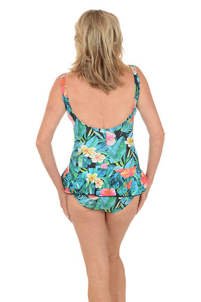 Woman wearing a colorful floral dress on a white background. Back shot.