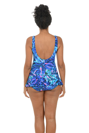 Woman wearing a blue and pink patterned swimsuit on a white background. Back shot.