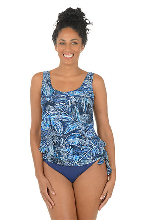 Woman wearing a blue leaf-patterned swimsuit on a white background.