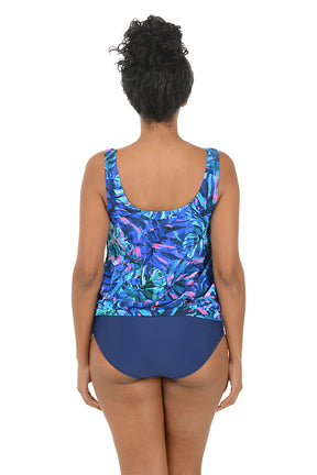 Woman wearing a colorful tankini top with a white background. Back shot.