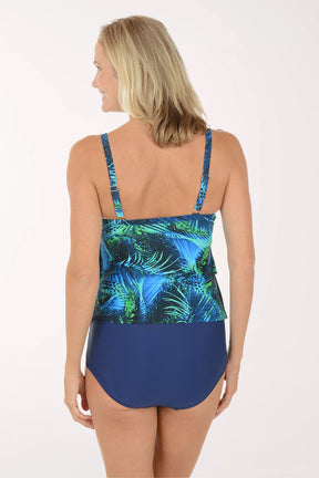 Woman wearing a blue and green leaf-patterned swimsuit on a white background. Back shot.
