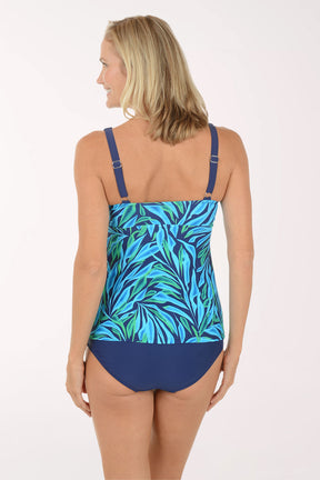 Woman wearing a blue and green leaf-patterned swimsuit on a white background
