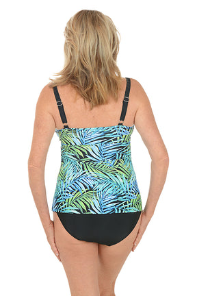 Woman wearing a tropical print tank top and black swimsuit bottom on a white background. Back shot.