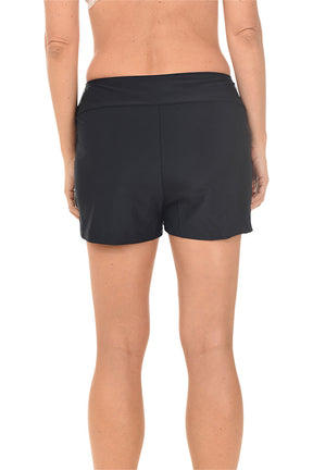 Black swim shorts worn by a person on a white background. Back shot.