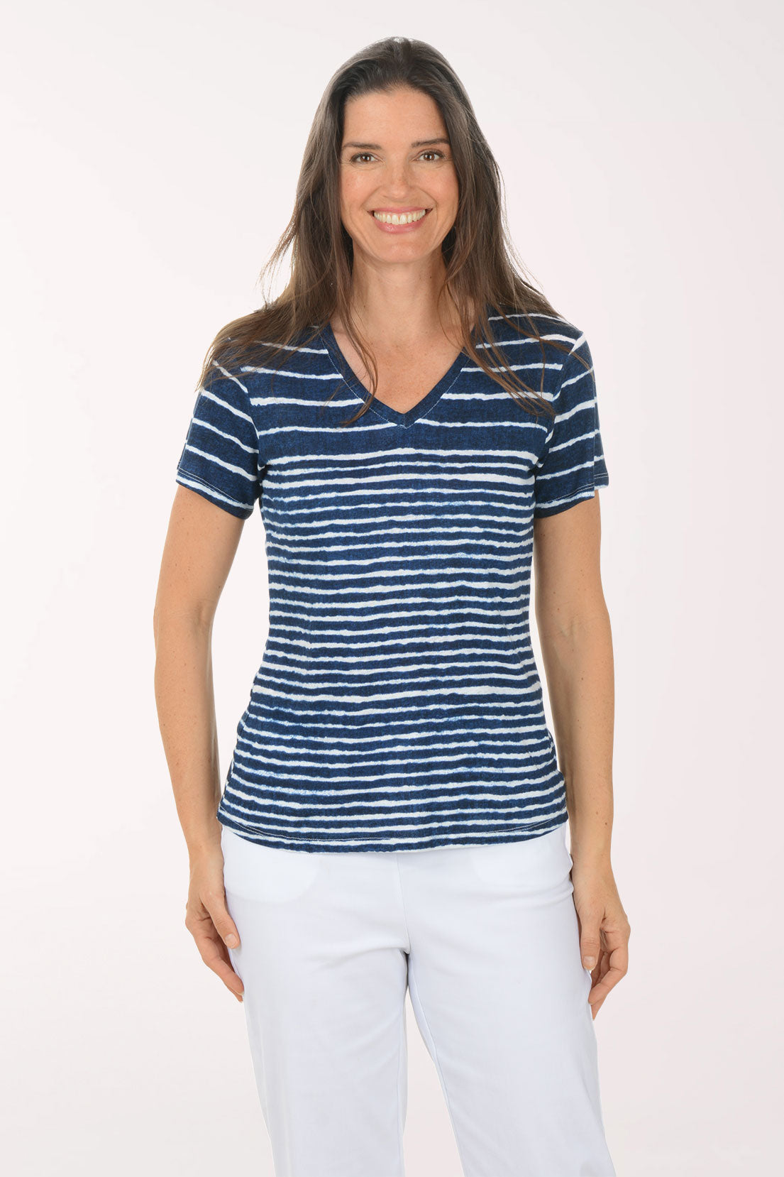 Woman wearing a blue and white striped shirt and white pants on a white background