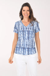 Woman wearing a blue and white patterned blouse on a white background