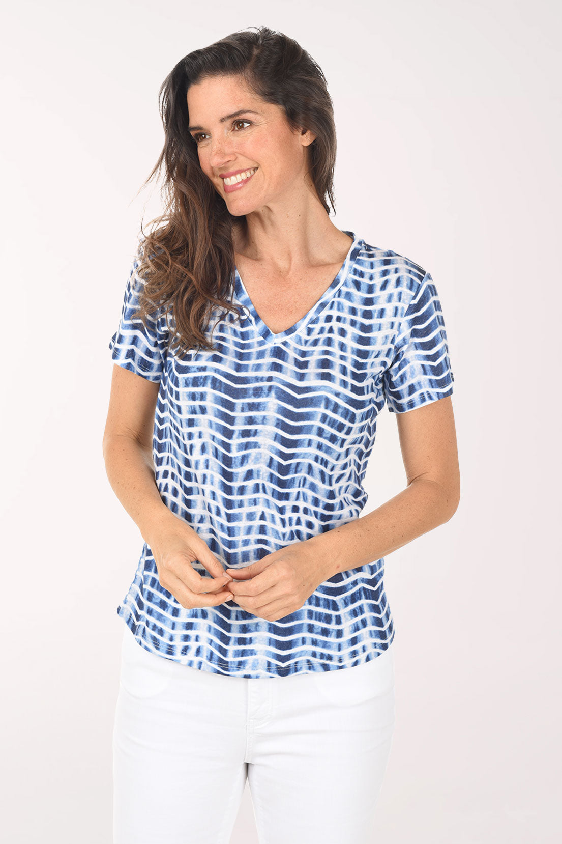 Woman wearing a blue and white patterned blouse on a white background