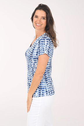 Woman wearing a blue and white patterned blouse on a white background