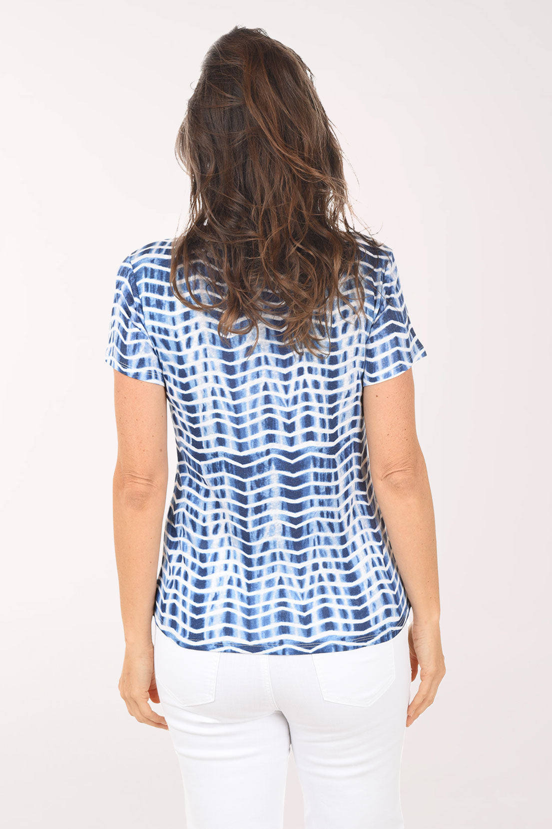 Woman wearing a blue and white patterned blouse on a white background