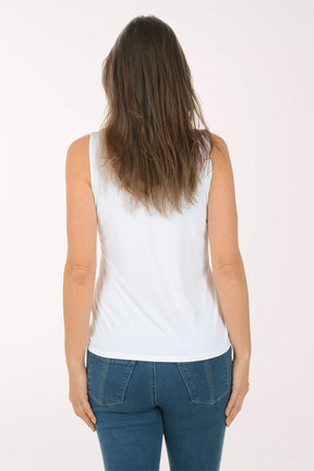 Woman wearing a white tank top and blue jeans on a white background