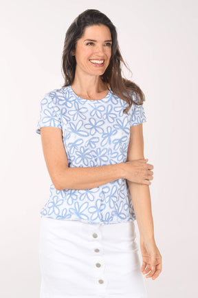 Woman wearing a blue floral patterned shirt on a white background