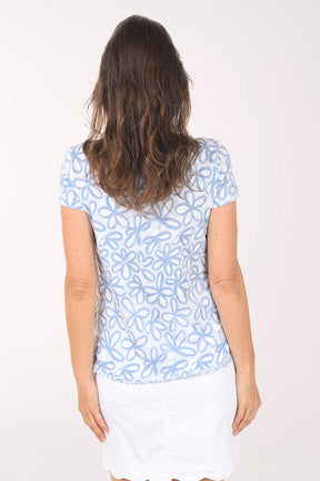 Woman wearing a blue floral patterned shirt on a white background