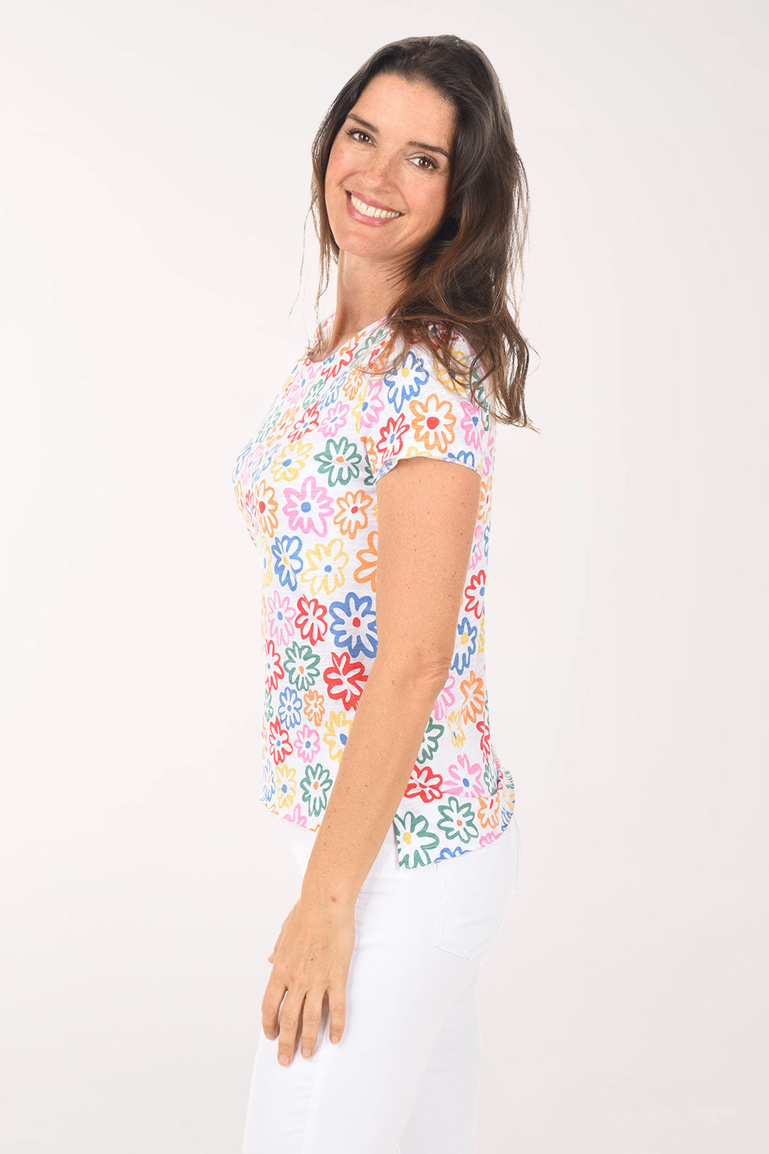 Woman wearing a colorful floral-patterned top on a white background