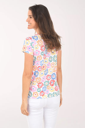 Woman wearing a colorful floral-patterned top on a white background