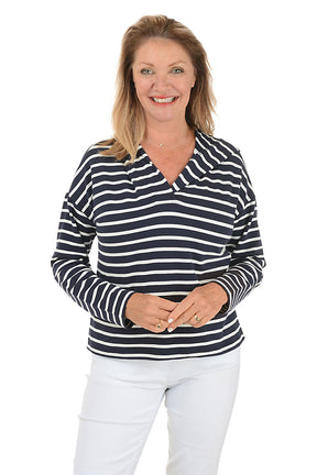A woman wearing a navy striped French terry hoodie with a V-neckline and long dolman sleeves.