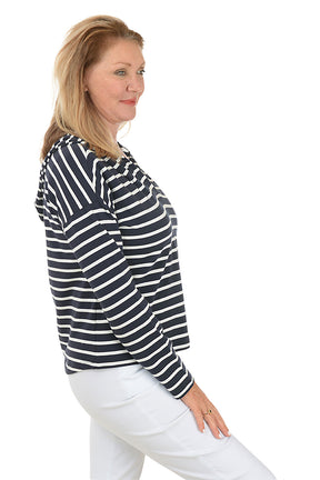A woman wearing a navy striped French terry hoodie with a V-neckline and long dolman sleeves. Side shot.