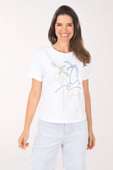 Woman wearing a white t-shirt with a graphic design on a plain background