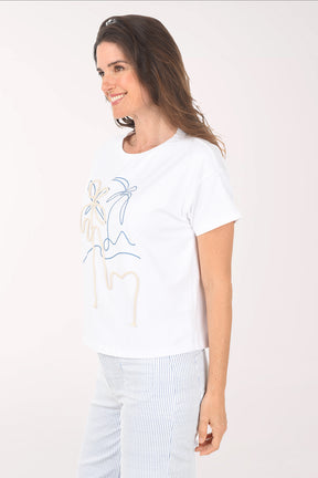 Woman wearing a white t-shirt with a graphic design on a plain background