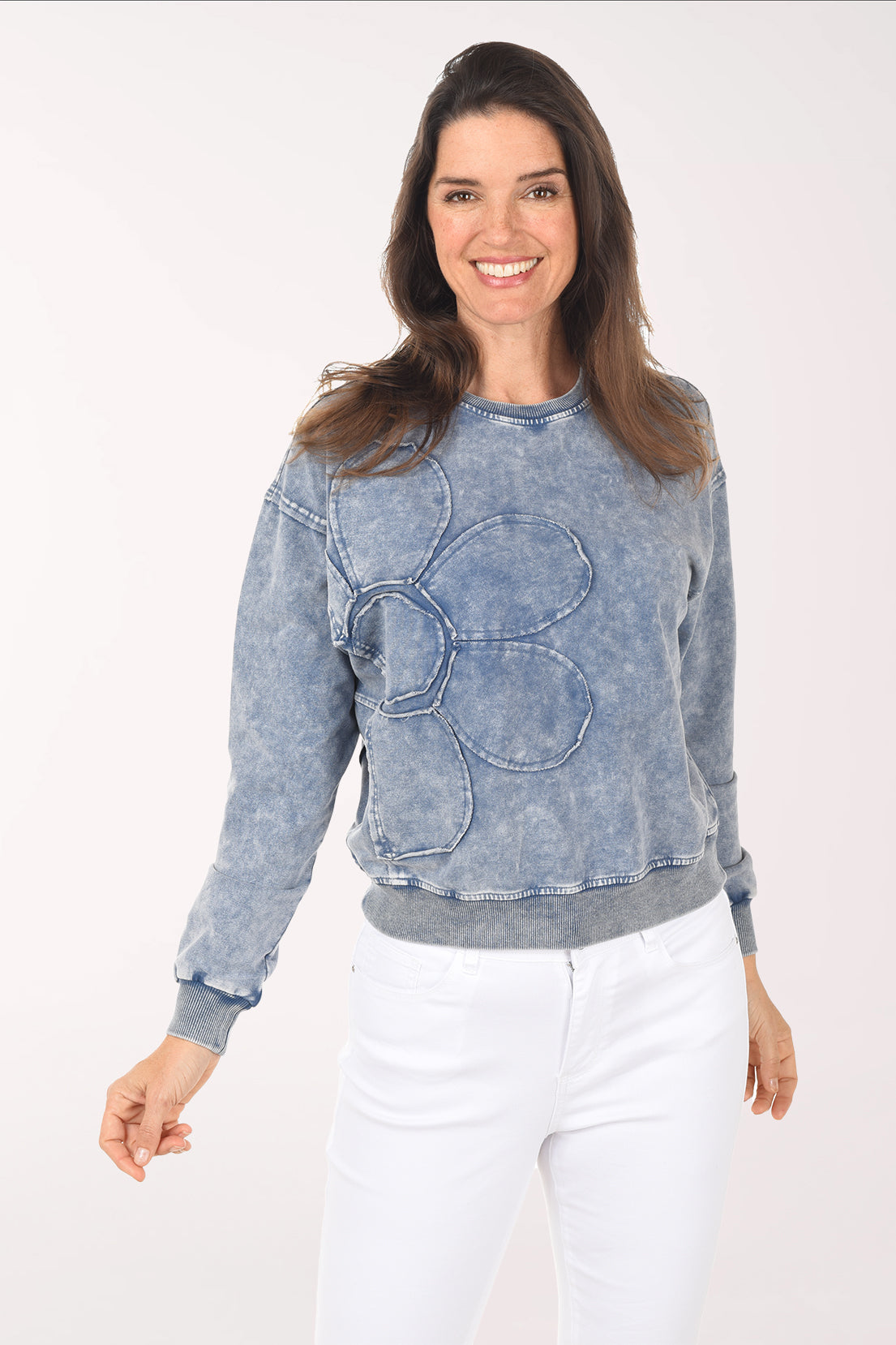 Woman wearing a blue acid-wash sweatshirt on a white background