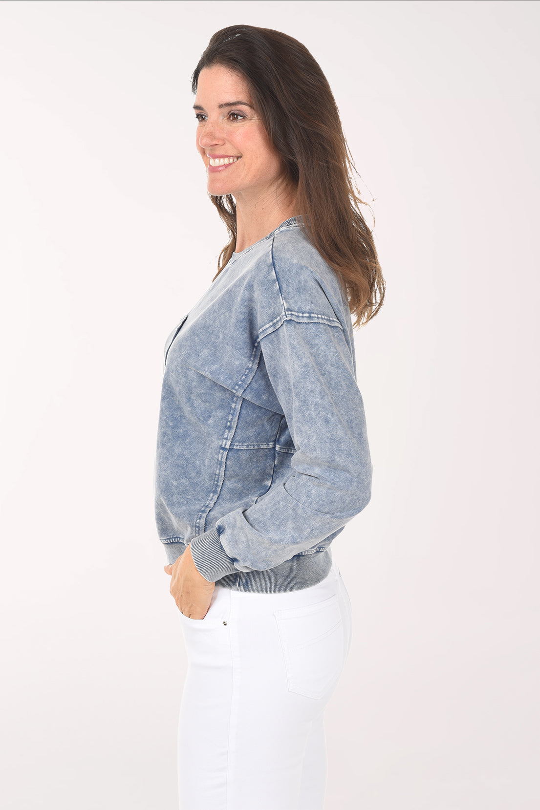 Woman wearing a blue acid-wash sweatshirt on a white background