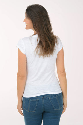 Woman wearing a white t-shirt with a blue heart design and blue jeans on a white background