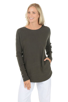Woman wearing a green sweater with button details on a white background.