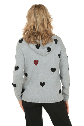 Woman wearing a gray hoodie with black heart patterns on a white background. Back shot.